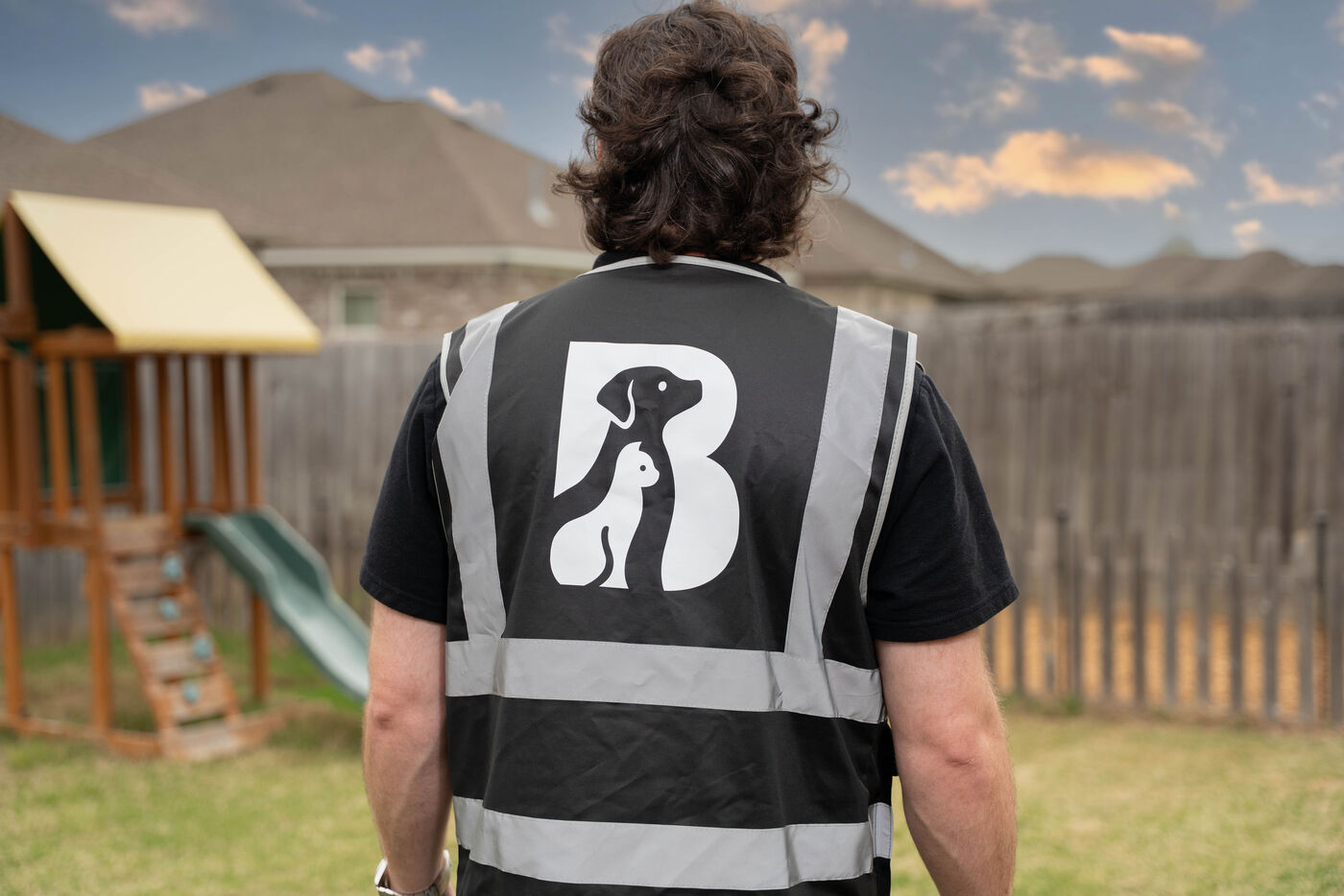 Photo of the back of a man wearing a shirt with the logo of Black Warrior Pet Waste Solutions