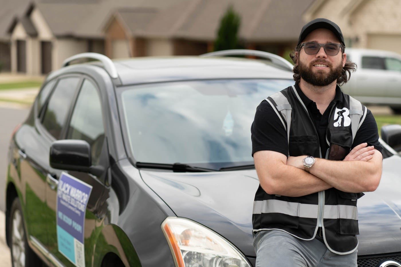 The owner, Colby, standing in front of a car with his arms crossed